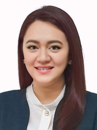 Professional woman smiling in business attire against a white background.