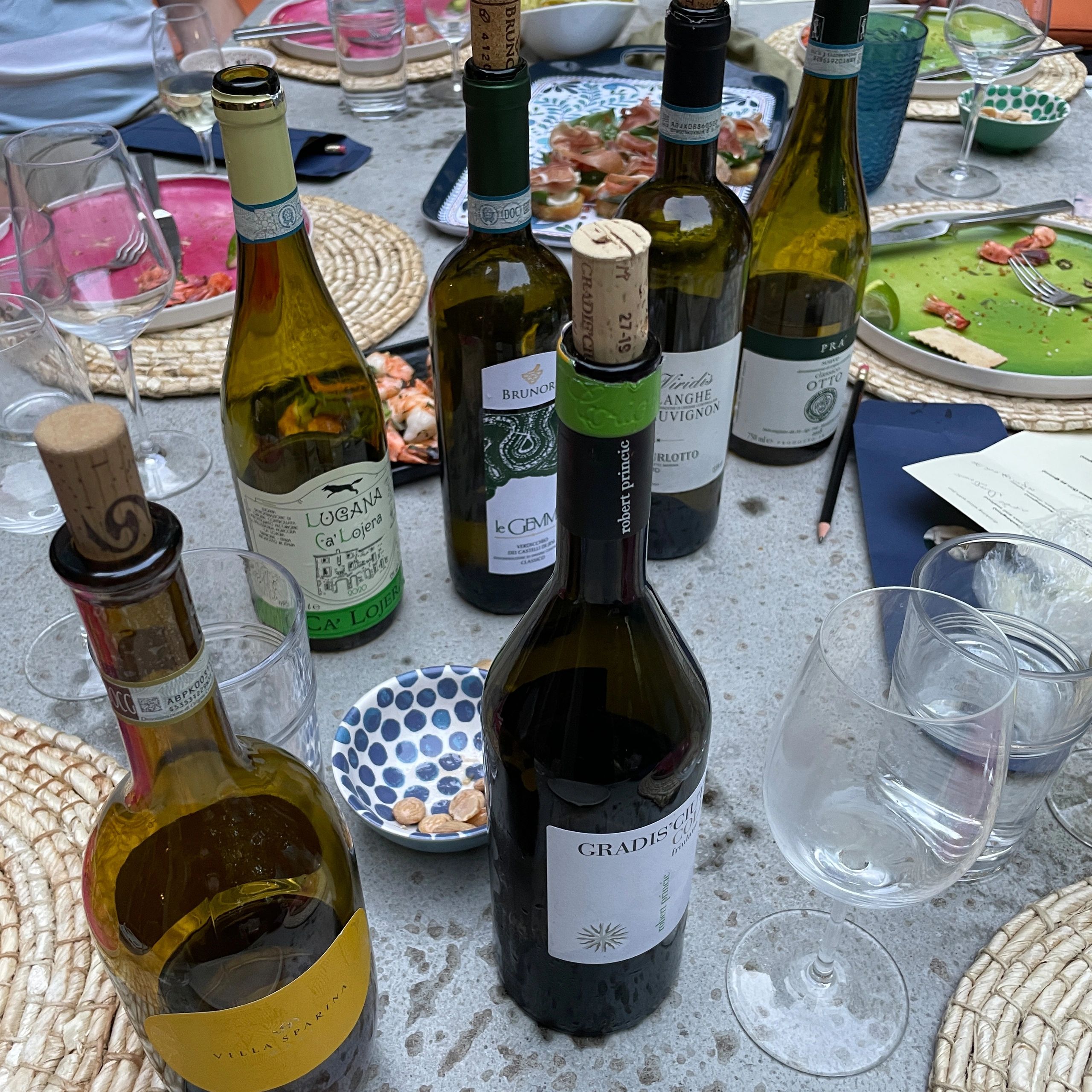 Bottles of wine and empty glasses on a table after a meal.