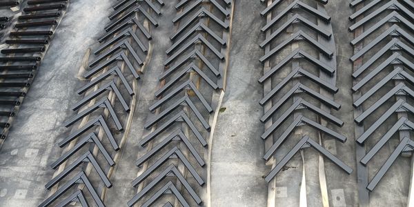 Artistic wall with repeating angled metal pieces.