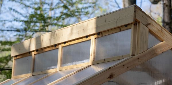 Photo of the top of the greenhouse where windows work as a cooling system.