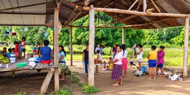 Comunidad reunida bajo un refugio rústico.