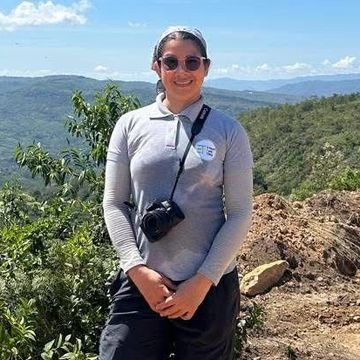 Persona con cámara en paisaje montañoso.