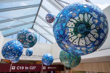 Blue glass art spheres suspended from a ceiling.