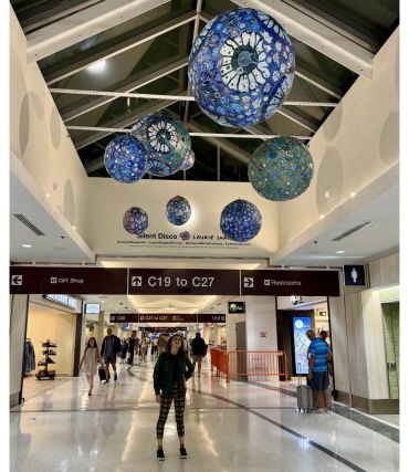 Blue decorative hanging globes in an airport terminal.