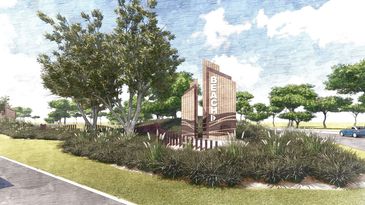 Landscaped beach entrance with a modern sign and lush greenery.