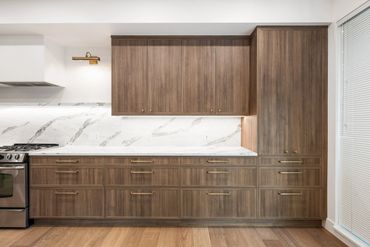 Modern kitchen with wood cabinets and marble backsplash.