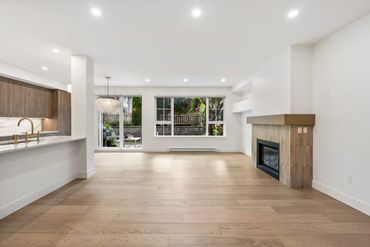 Bright, spacious living room with wood floors and a modern fireplace.