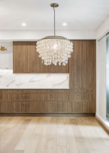 Modern kitchen with wood cabinetry and a decorative pendant light.