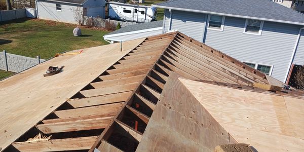 Roof under construction with plywood sheets being installed.
