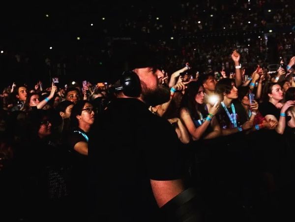 Man with headphones at a crowded concert.