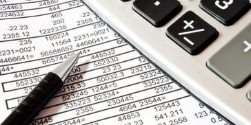 Close-up of financial documents with pen and calculator.