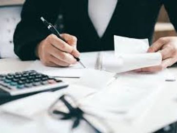 Person calculating finances with documents and calculator on desk.
