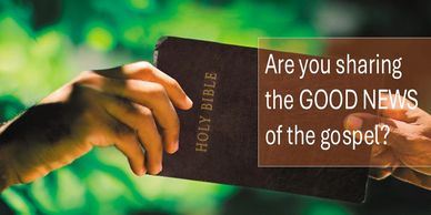 Hands exchanging a Holy Bible with a gospel-sharing message.