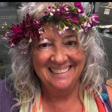 Smiling woman wearing a floral crown.