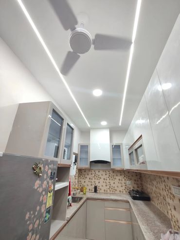 Modern kitchen with ceiling fan and LED lights.