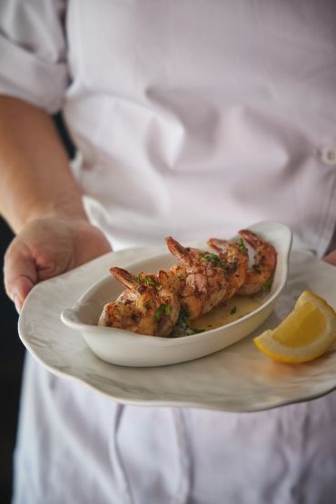 Crevettes grillées présentées avec un quartier de citron.
