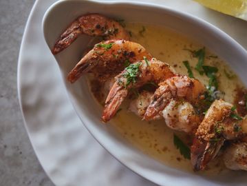 Crevettes grillées avec sauce et herbes.