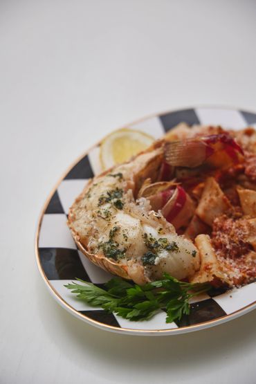 Un plat de fruits de mer avec du persil et du citron.