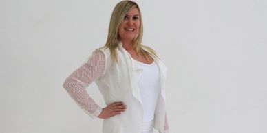 Femme souriante en tenue blanche.