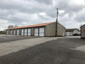 Large industrial garage with multiple bays under a cloudy sky.