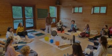 Groupe de personnes assises en cercle dans une salle en bois.