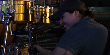Person smiling while adjusting drums.