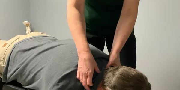 Adult male face down on the table while the chiropractor evaluates his neck. 