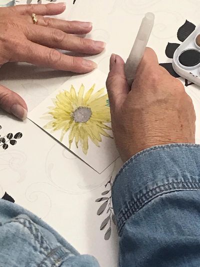 Photo of artist drawing a sunflower.