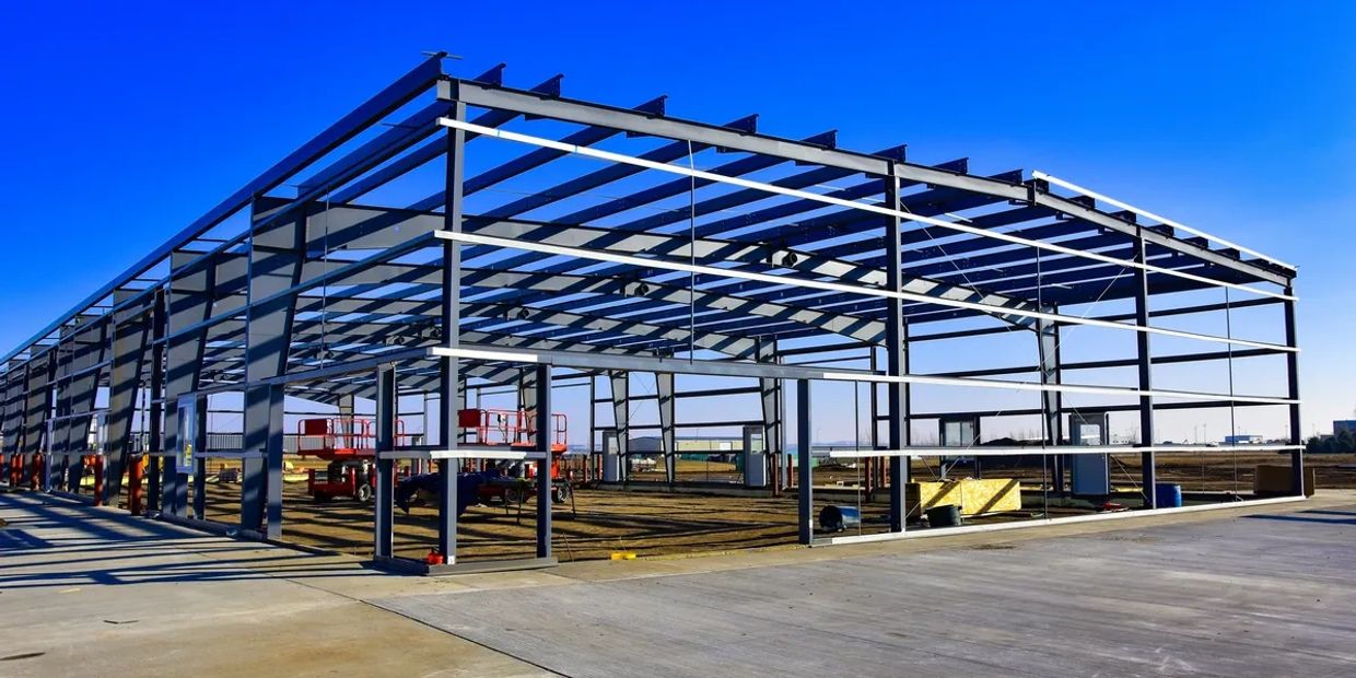 Steel frame structure of a building under construction on a clear day.