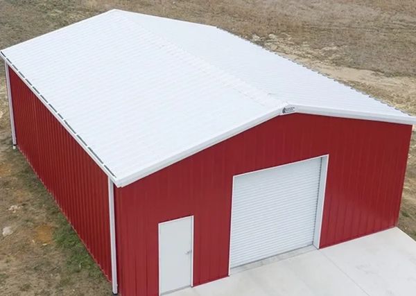 Large red metal storage building with white roof and doors.