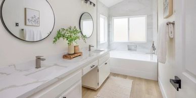 Modern bathroom with double sinks and bathtub.