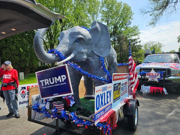 Political parade float with elephant and campaign signs.
