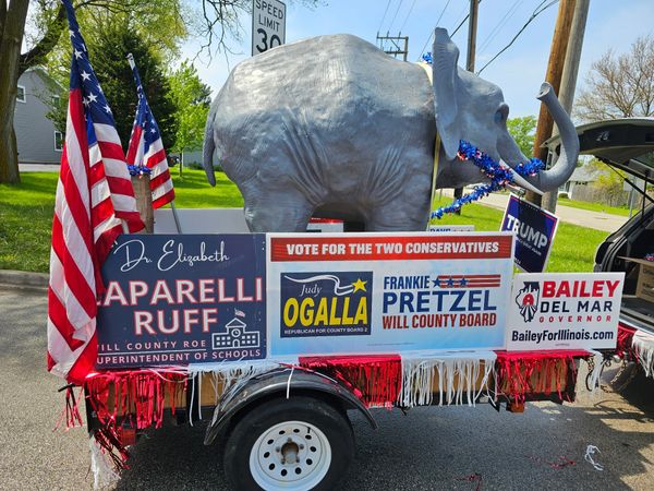 Patriotic campaign float with elephant and conservative political signs.