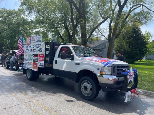 White truck decorated with political signs and American flags.