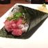 Sushi rolled in a cone and garnished with fish and spring onions 