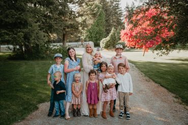 Family group photo outdoors with children and an adult.
