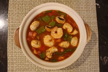 a bowl of soup with shrimps 