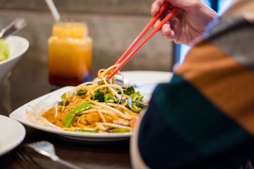 closeup shot of a person eating thai food 