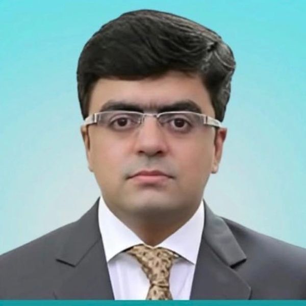Professional headshot of a man in glasses with a suit and tie.