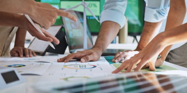 People collaborating over charts and data in a business meeting.