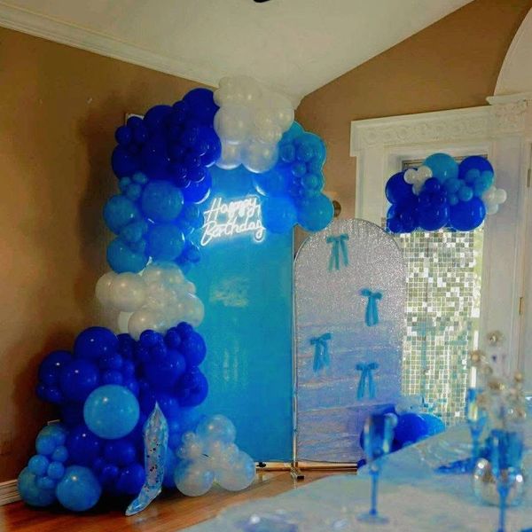 Blue and white balloon birthday decoration with a neon Happy Birthday sign.