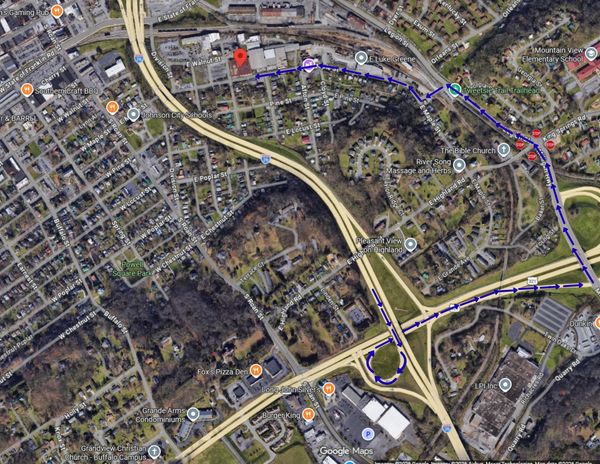 Satellite map showing a route marked with blue arrows across a suburban area.