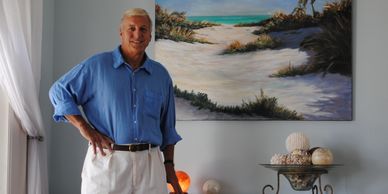 Tropical Artist, Alan Zawacki, with one of his original tropical paintings in a customer's home