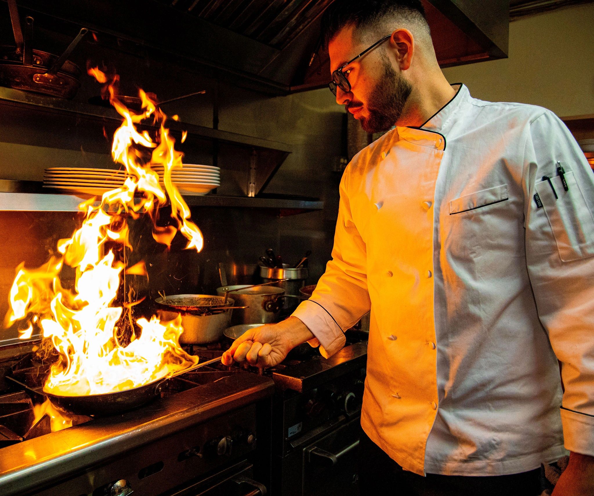 A picture of the chef holding the pan in the kitchen