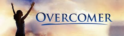 Silhouette of a person raising arms with the word 'OVERCOMER' against a sunrise or sunset sky.