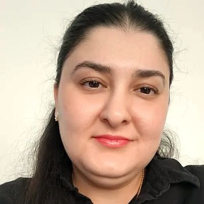 Close-up portrait of a woman with dark hair and a subtle smile.