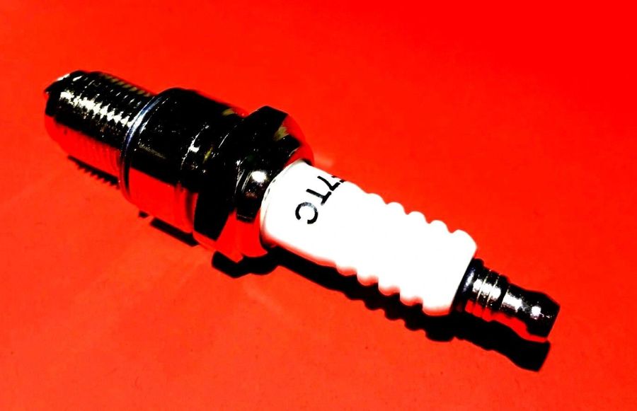 Close-up of a spark plug on a red background