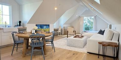 Bright attic living space with a dining table and cozy sitting area.