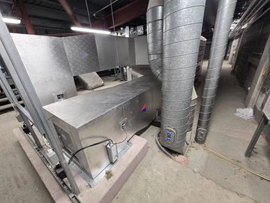 Industrial HVAC ductwork and ventilation system in a basement.