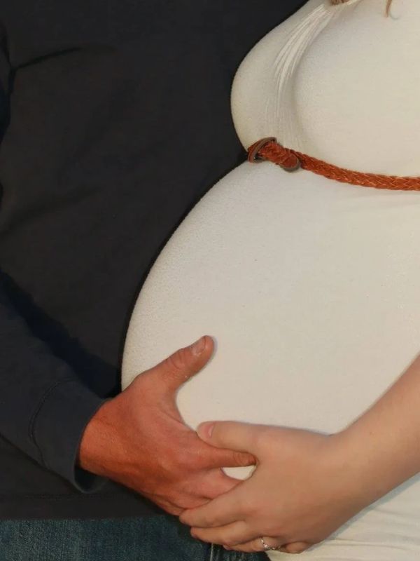 Hands gently holding a pregnant belly, symbolizing love and anticipation.